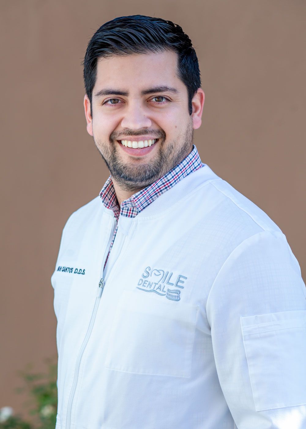 Dr. Santos in a Smile Dental coat, smiling
